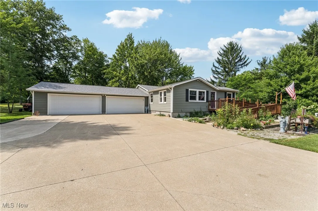 View of front facade featuring driveway and a deck
