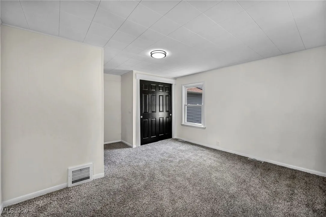 Carpeted empty room with baseboards