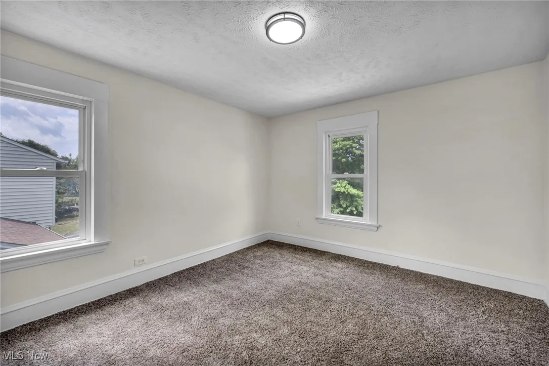 Empty room featuring carpet floors and a textured ceiling