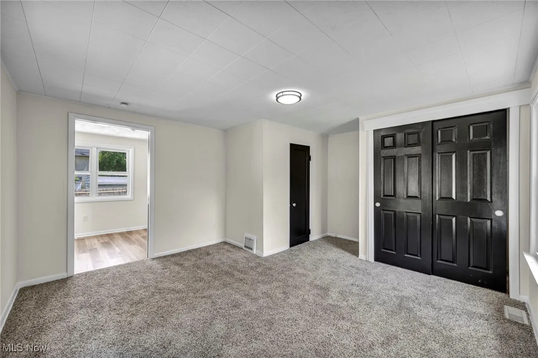 Unfurnished bedroom with carpet and a closet