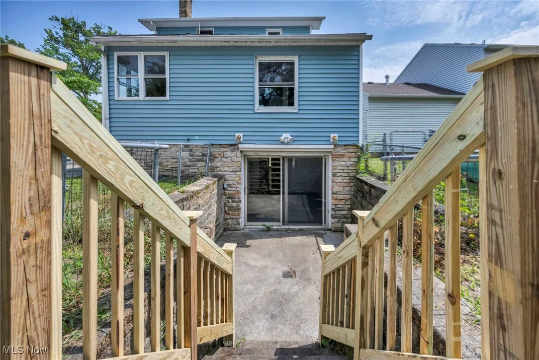 Rear view of property featuring stone siding