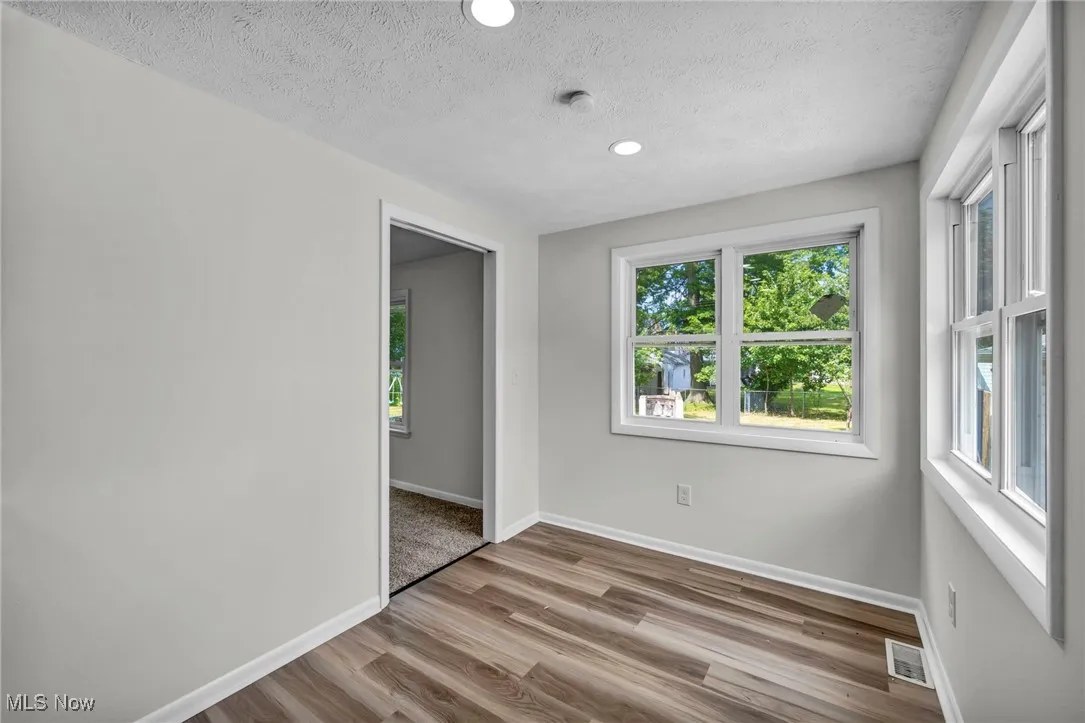 Unfurnished room featuring light wood-style floors, a textured ceiling, and recessed lighting