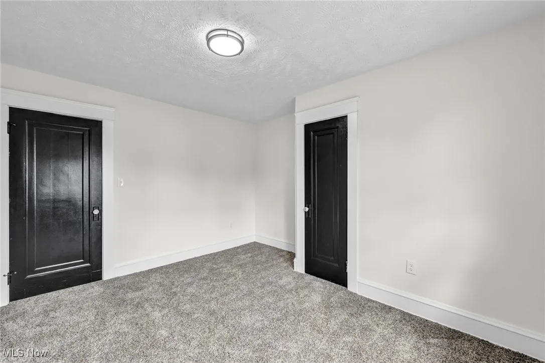 Unfurnished bedroom with a textured ceiling and carpet flooring