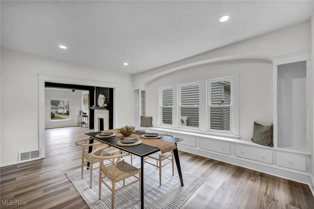 Dining area with recessed lighting, light wood-style flooring, and a fireplace