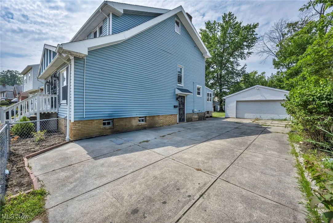 View of side of home featuring an outbuilding and a garage