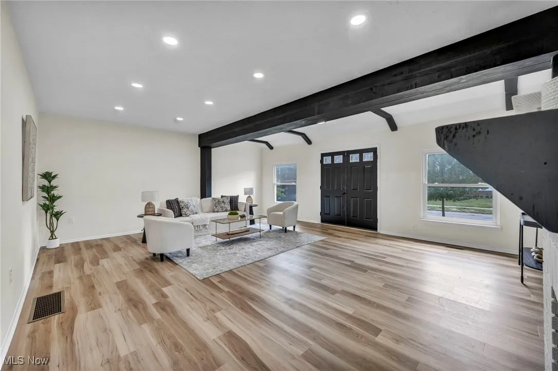 Living room featuring beam ceiling, recessed lighting, and light wood-style floors