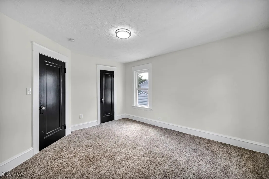 Unfurnished bedroom featuring carpet and a textured ceiling