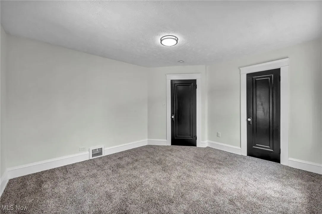 Unfurnished bedroom with a textured ceiling and carpet