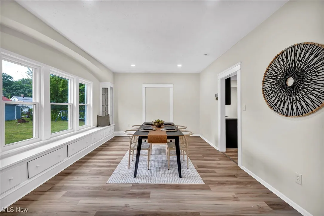 Dining room with light wood-style floors and recessed lighting