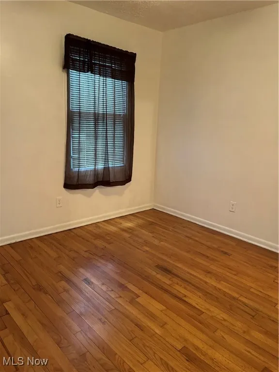 Spare room featuring hardwood / wood-style flooring and a textured ceiling