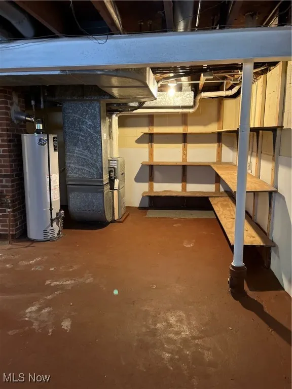 Unfinished area of basement with heating unit and water heater