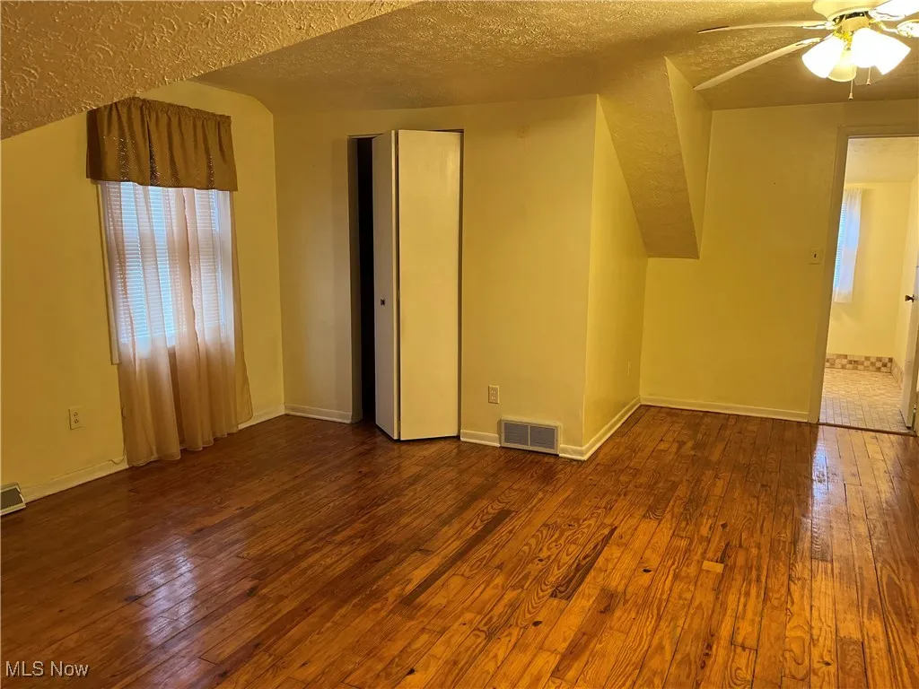 2nd floor master bedroom-space featuring dark wood-style floors, a textured ceiling, and a ceiling fan