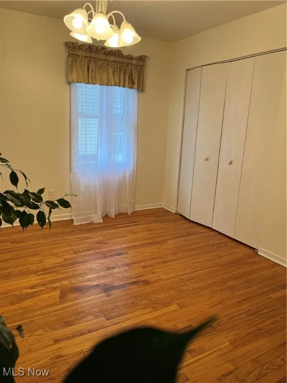 Dining area with hardwood / wood-style floors and a chandelier