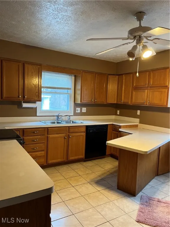 Kitchen with a textured ceiling, brown cabinetry, light tile patterned floors, light countertops, and dishwasher
