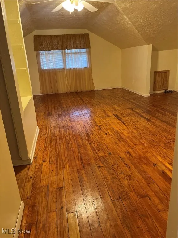 2nd floor master bedroom, textured ceiling, wood-type flooring, vaulted ceiling, and a ceiling fan