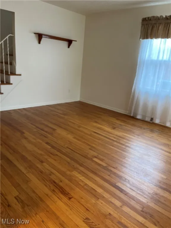 Unfurnished living room with light wood-type flooring and stairway