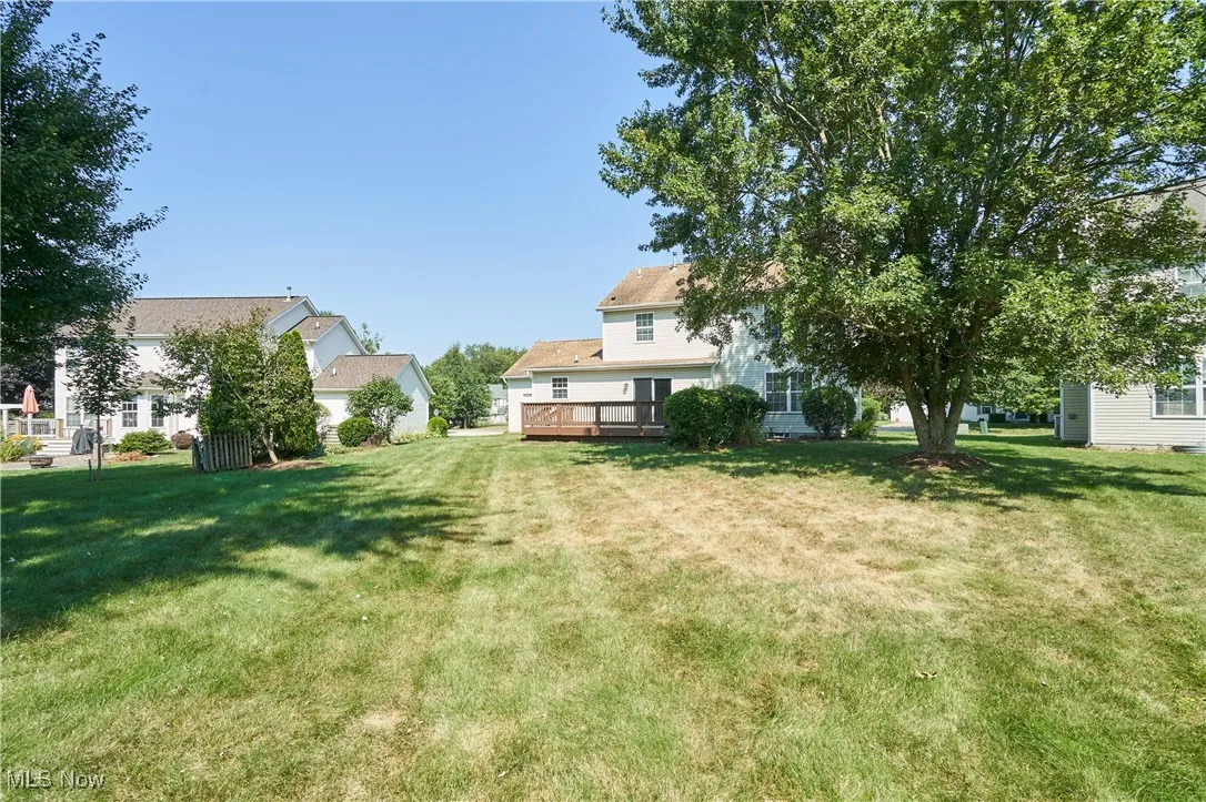 View of green lawn with a wooden deck