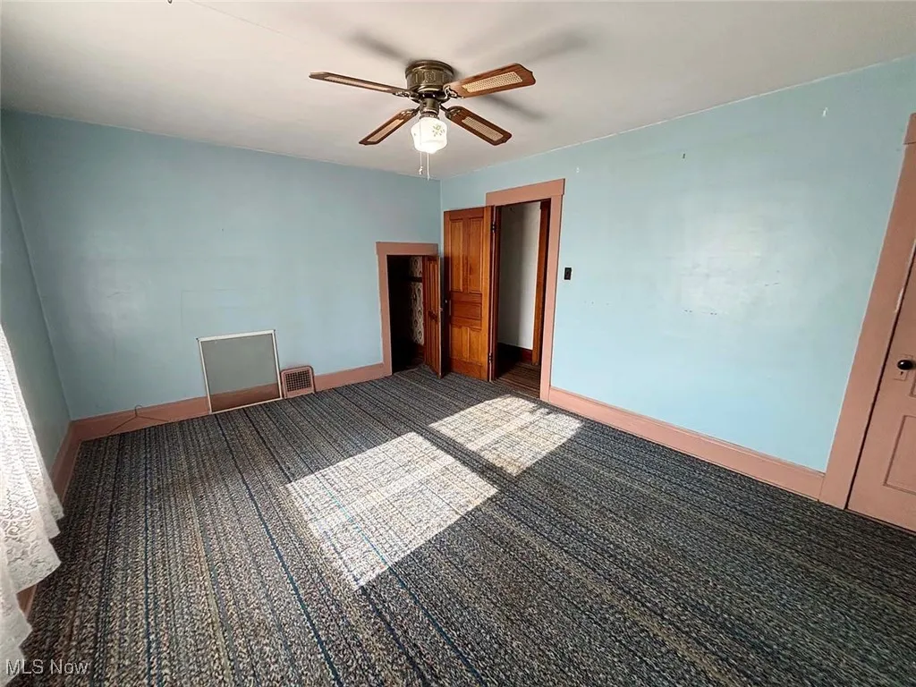 Unfurnished bedroom featuring ceiling fan and carpet floors