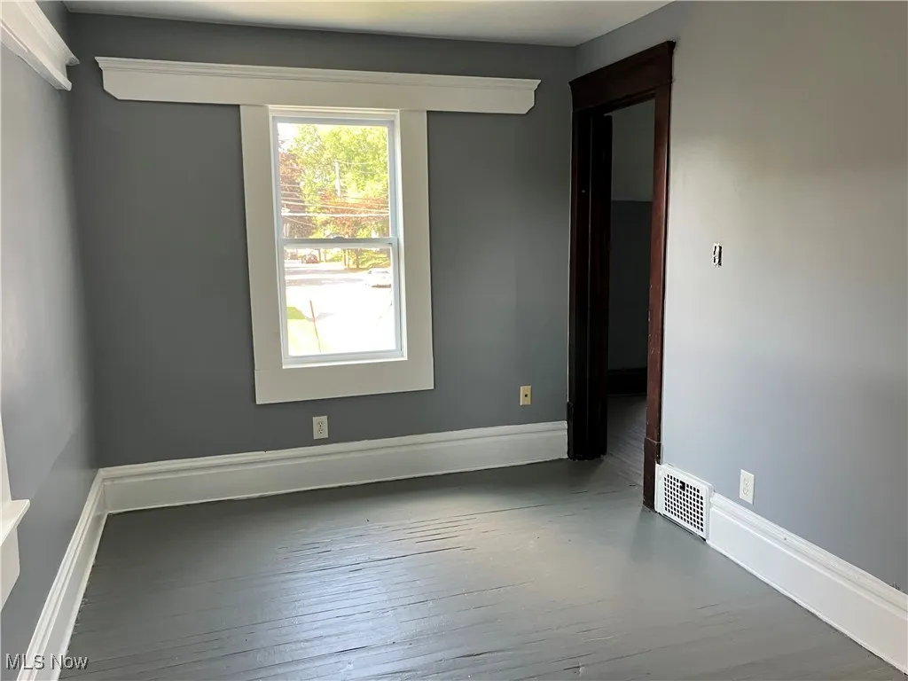 Spare room with hardwood / wood-style floors and baseboards