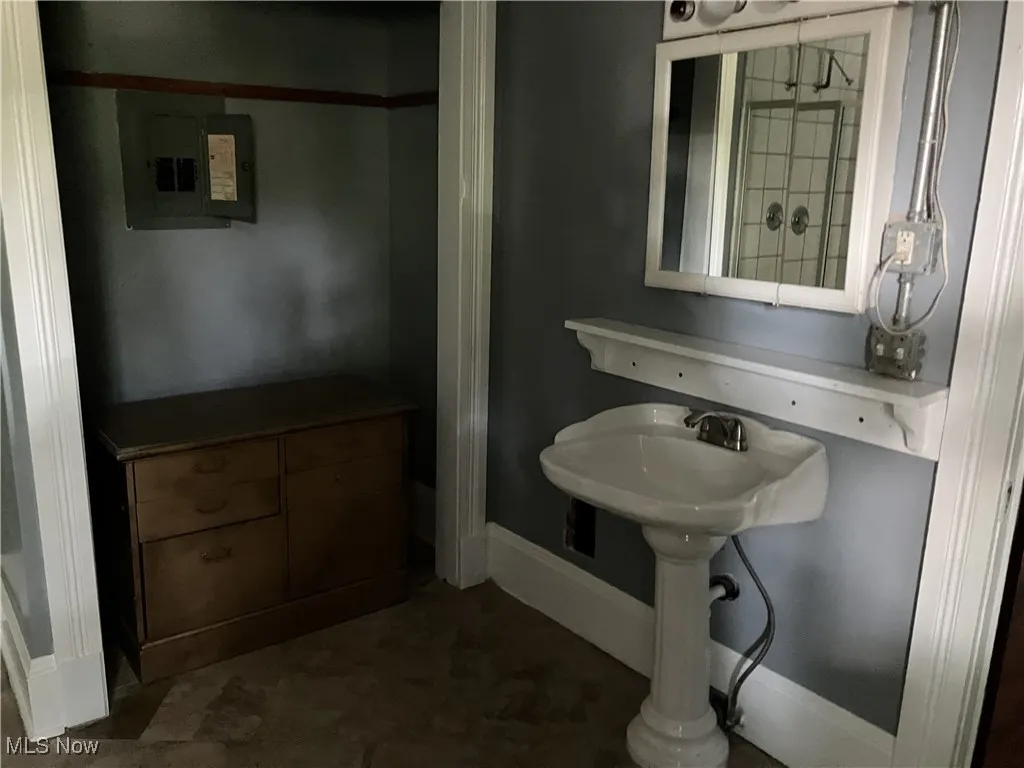 Bathroom with electric panel and baseboards