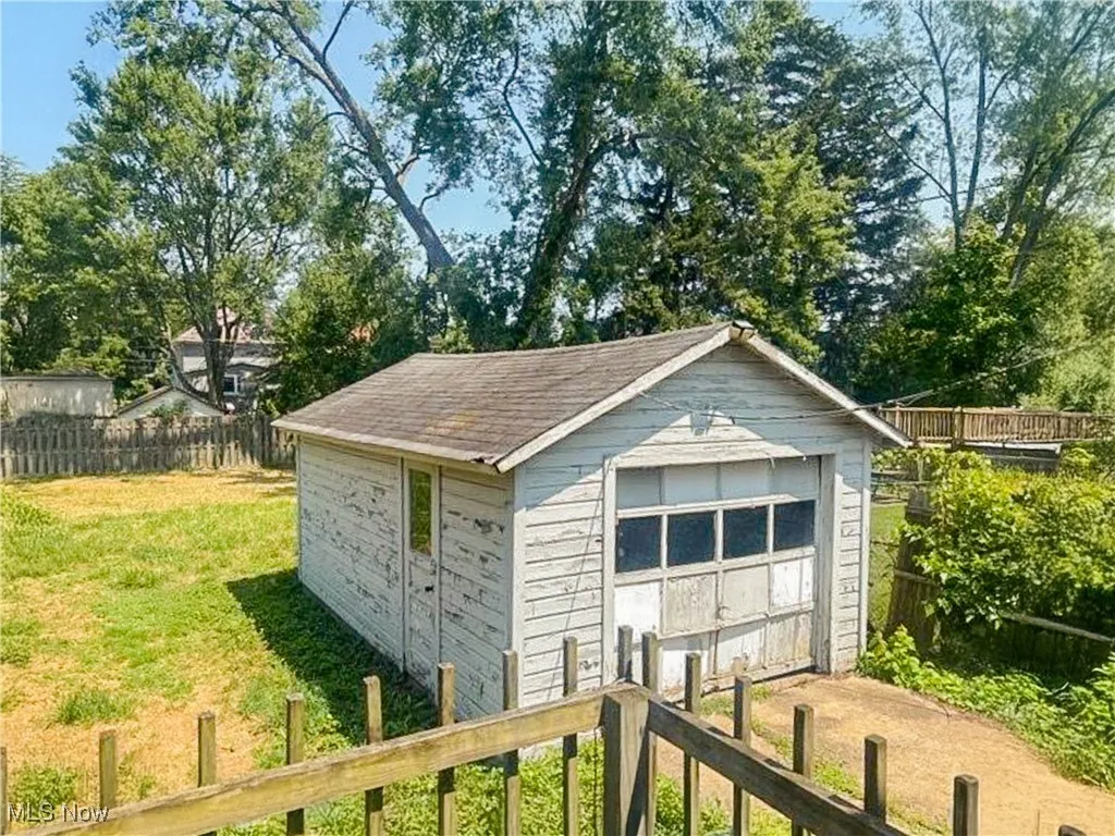 Detached garage with view of wooded area