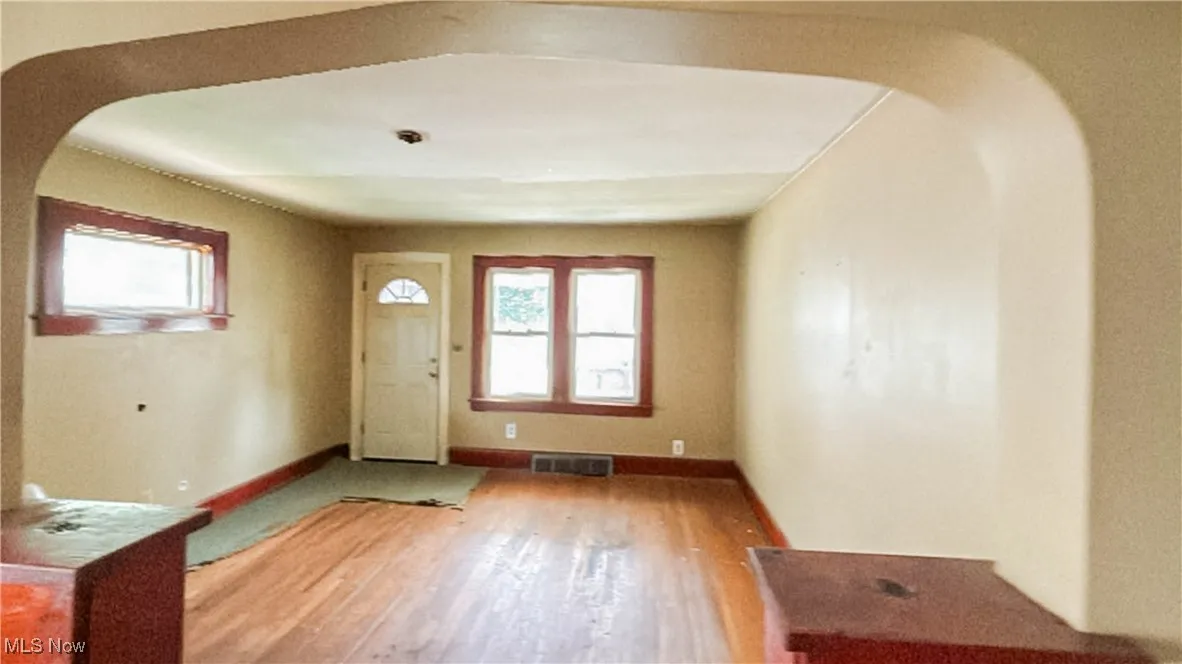 Foyer with wood finished floors and arched walkways