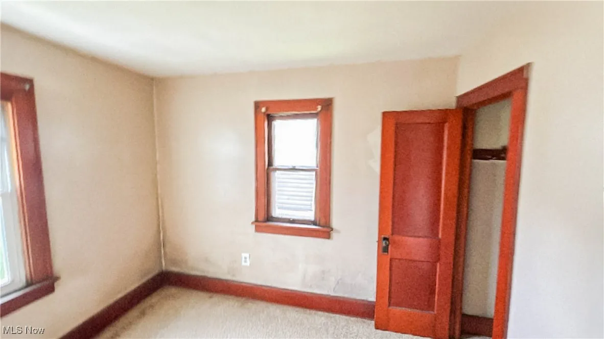 Unfurnished bedroom featuring baseboards and carpet