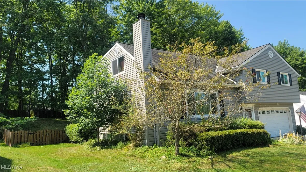 View of front of property featuring an attached garage and a chimney