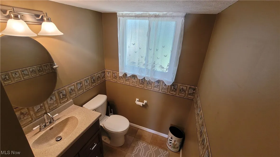 Bathroom featuring vanity, tile patterned floors, and a textured ceiling