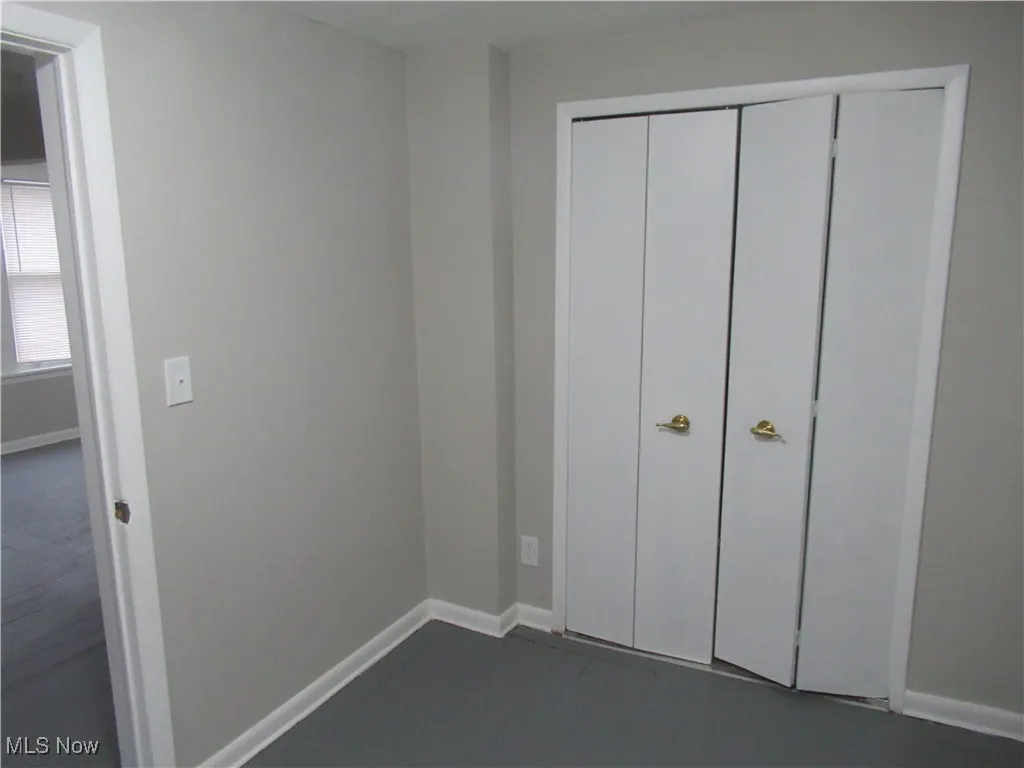 Unfurnished bedroom featuring baseboards and a closet
