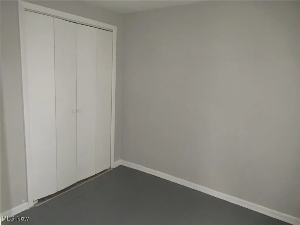 Unfurnished bedroom with a closet and baseboards