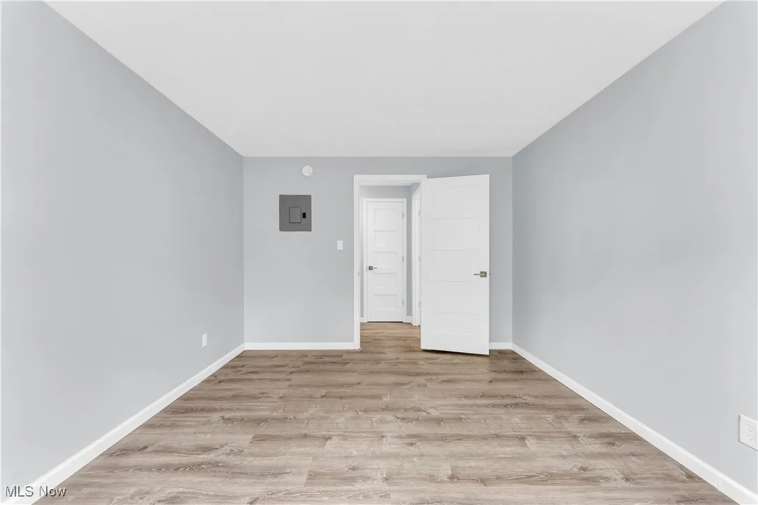 Unfurnished room featuring light wood-type flooring and electric panel