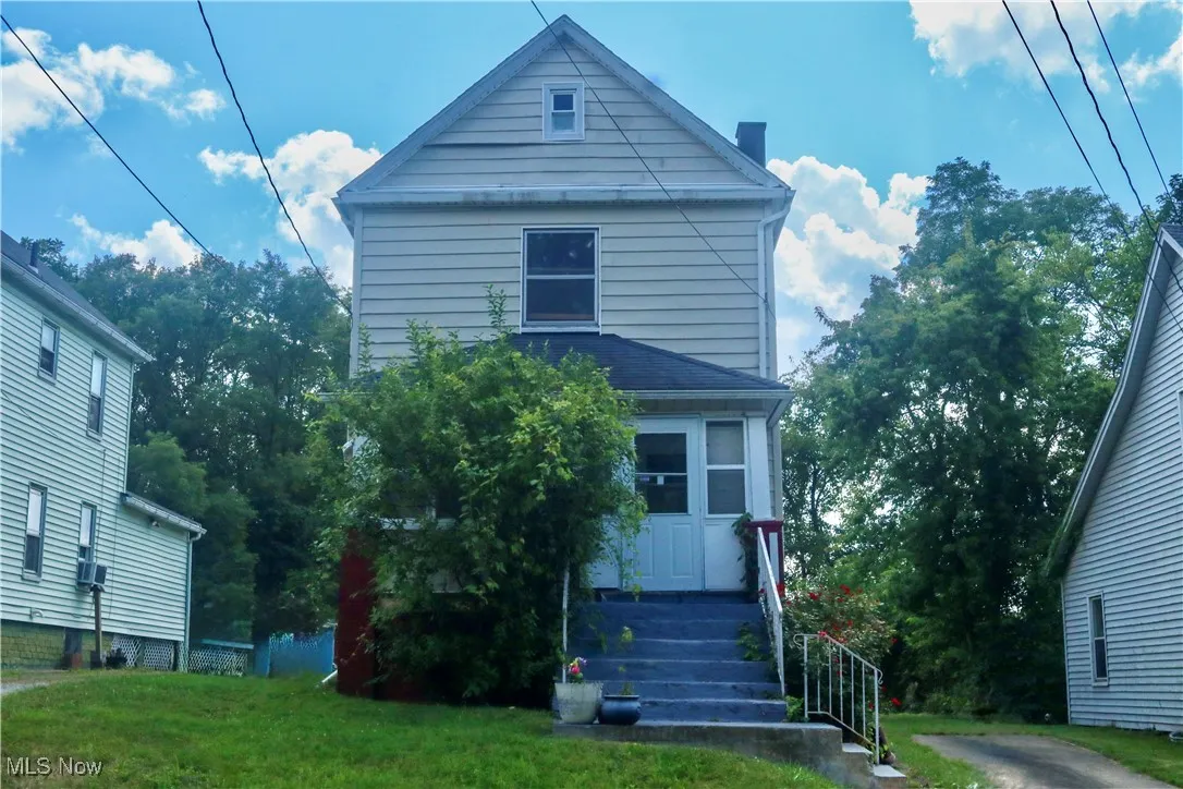 View of front of home featuring a chimney and a front lawn