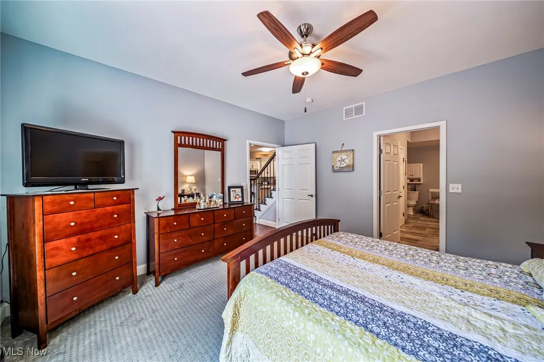 Carpeted bedroom with a ceiling fan and baseboards