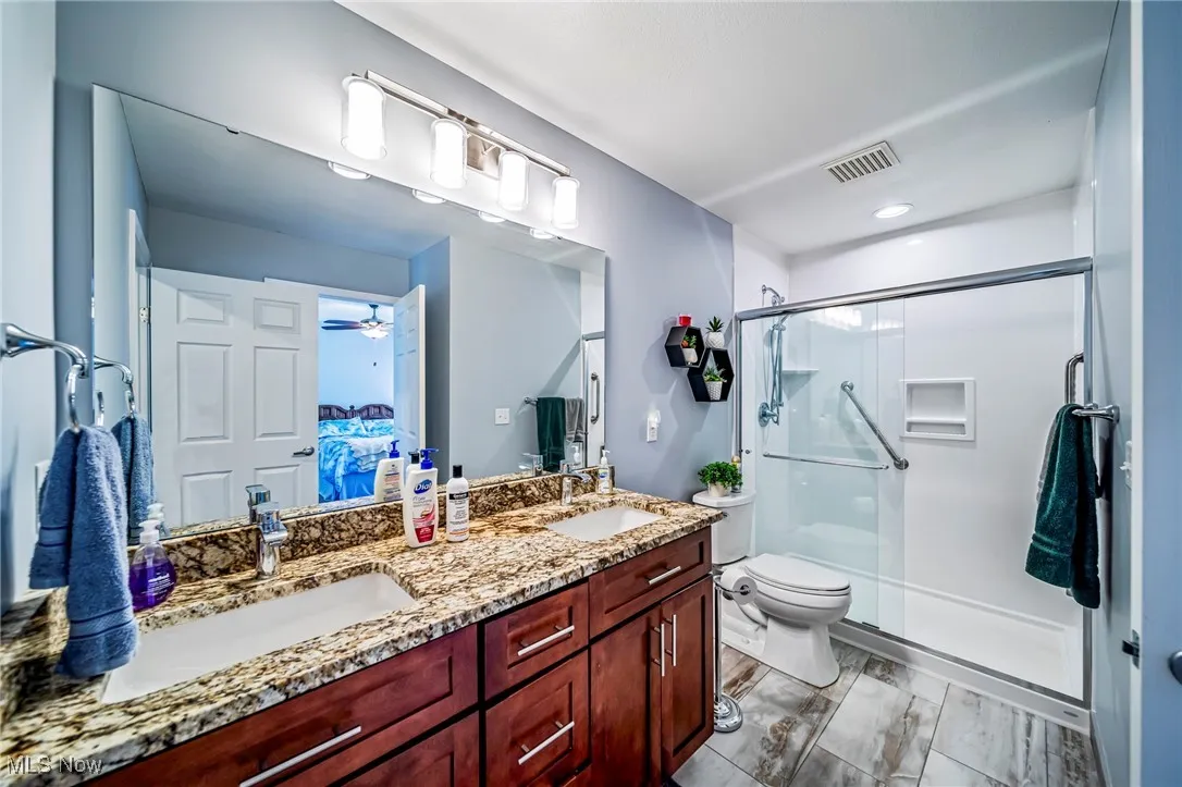 Bathroom featuring a stall shower, ensuite bathroom, and ceiling fan