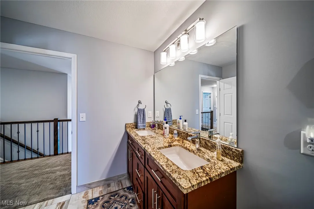 Full bath featuring a sink and light tile patterned floors