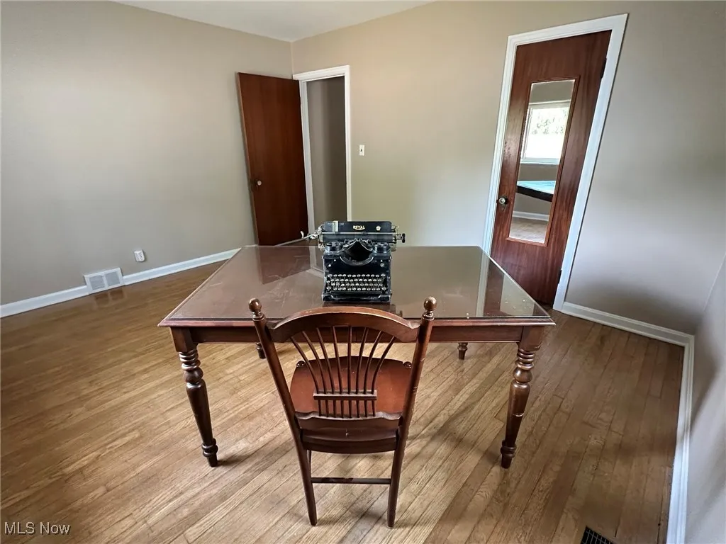 Office area with baseboards and wood finished floors