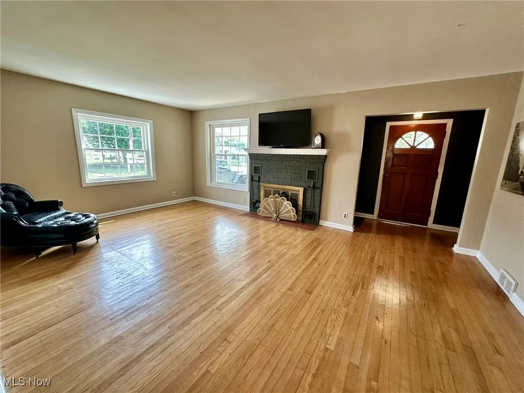 Unfurnished living room with a fireplace and light wood-style flooring