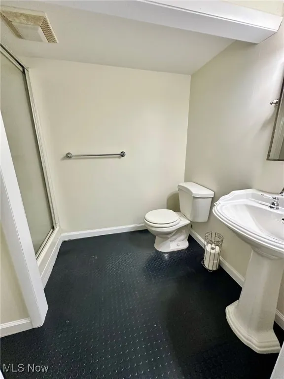 Bathroom featuring a stall shower and toilet