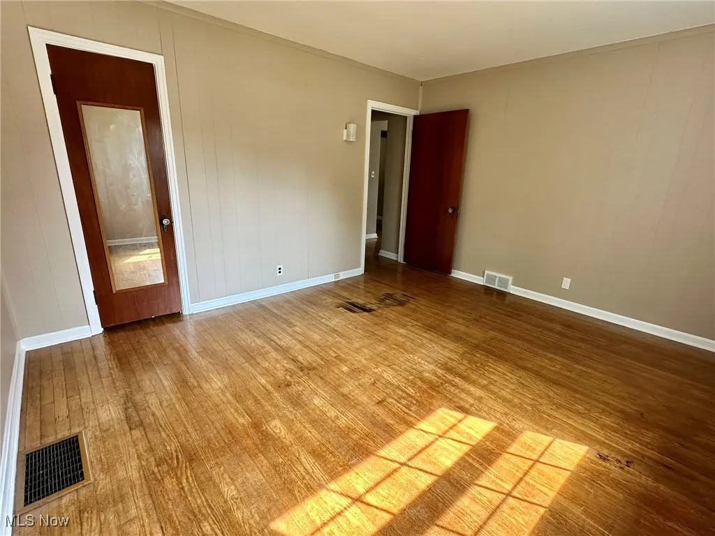 Spare room with wooden walls and wood finished floors