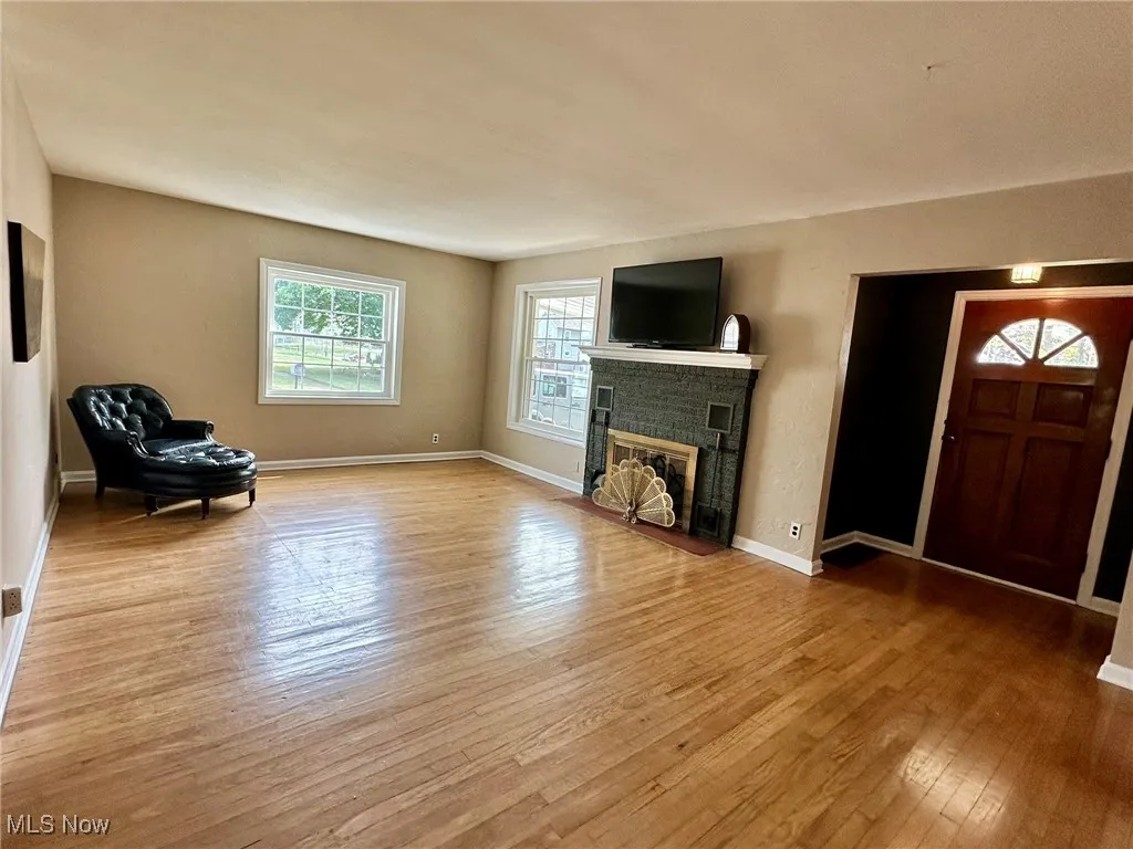 Unfurnished living room with light wood-style floors and a fireplace with flush hearth