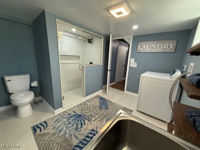 Full bathroom with light tile patterned floors, a stall shower, recessed lighting, and independent washer and dryer