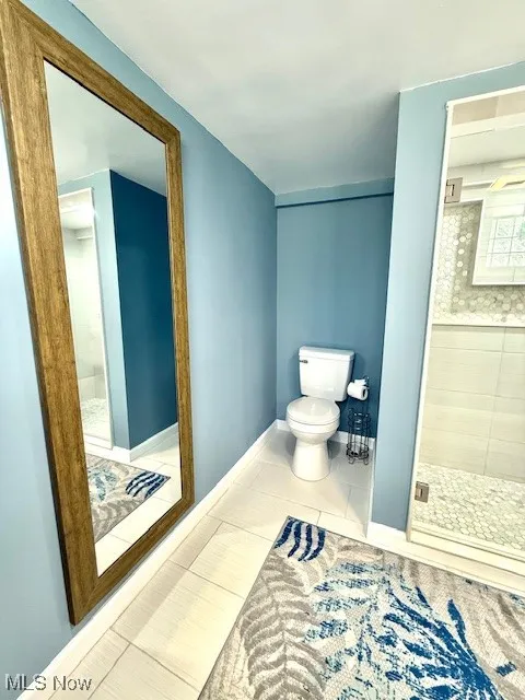 Full bath with a shower stall and tile patterned flooring