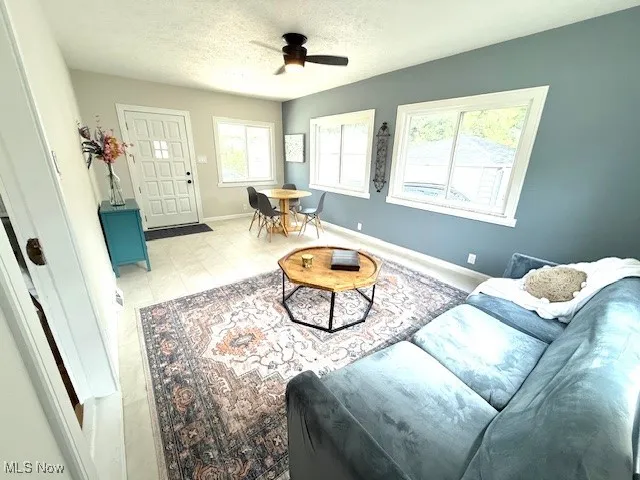 Living area with a textured ceiling and ceiling fan