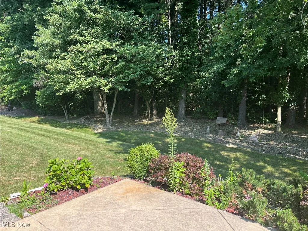 View of grassy yard with a patio area