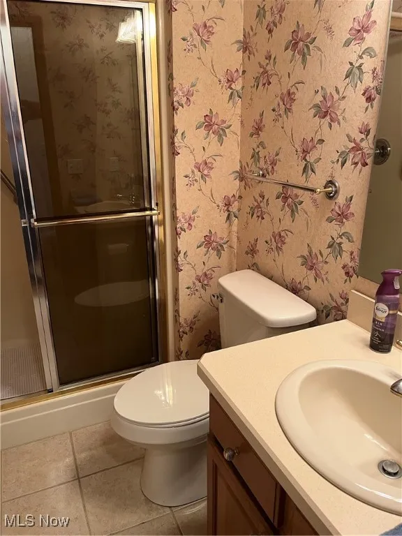 Bathroom featuring vanity, a shower stall, and light tile patterned flooring
