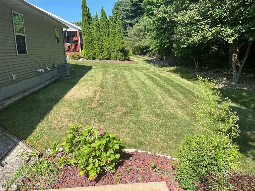 View of grassy yard with a wooden deck