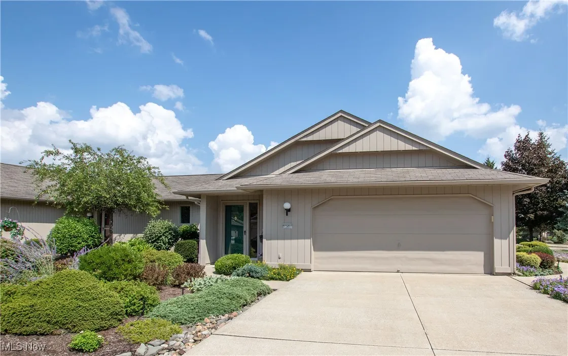 Single story home featuring a garage, driveway, and a shingled roof