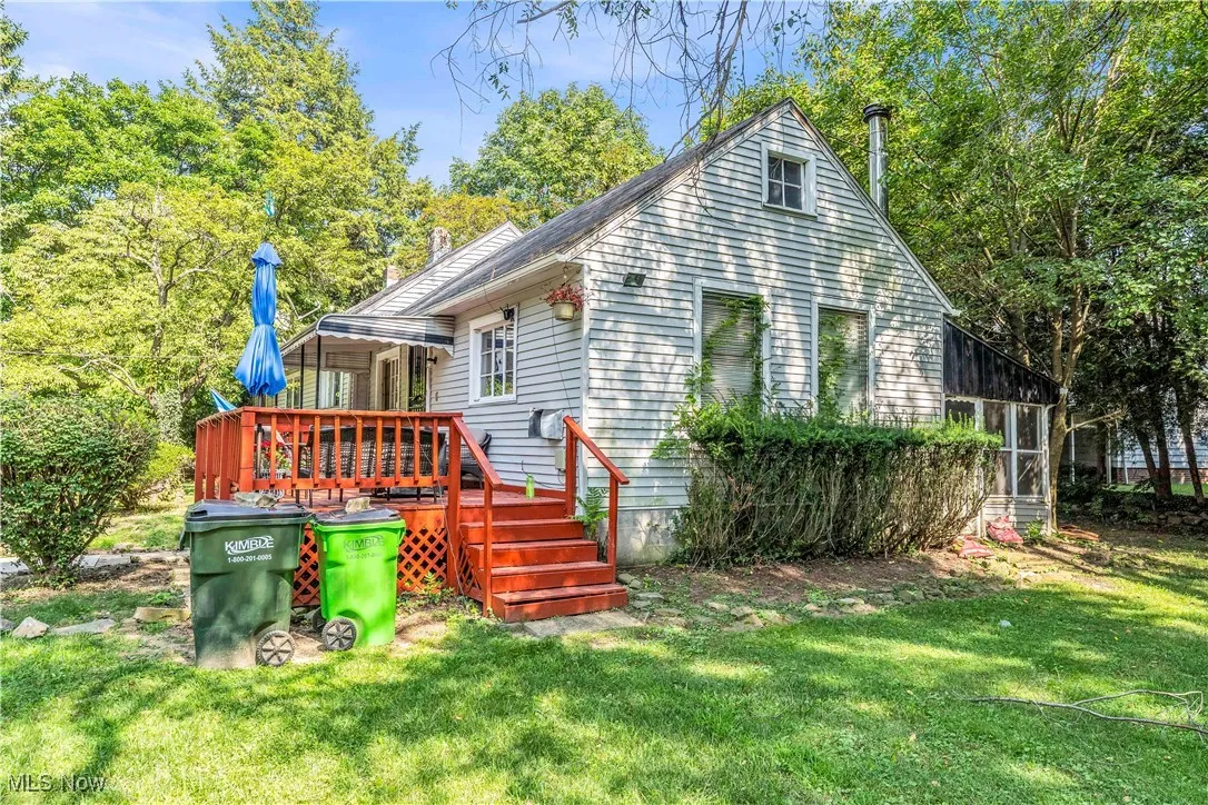 Back of property with a yard and a deck