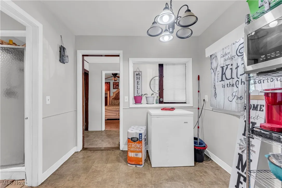 Laundry room featuring a chandelier and light tile patterned floors